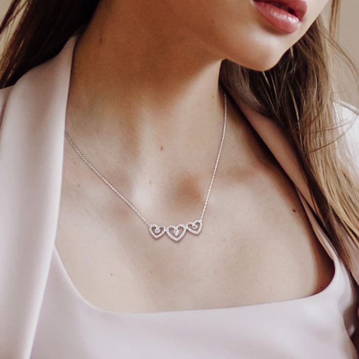 1/2 CT TGW White Topaz and 1/5 CT TW Diamond Triple Heart Necklace in
Sterling Silver