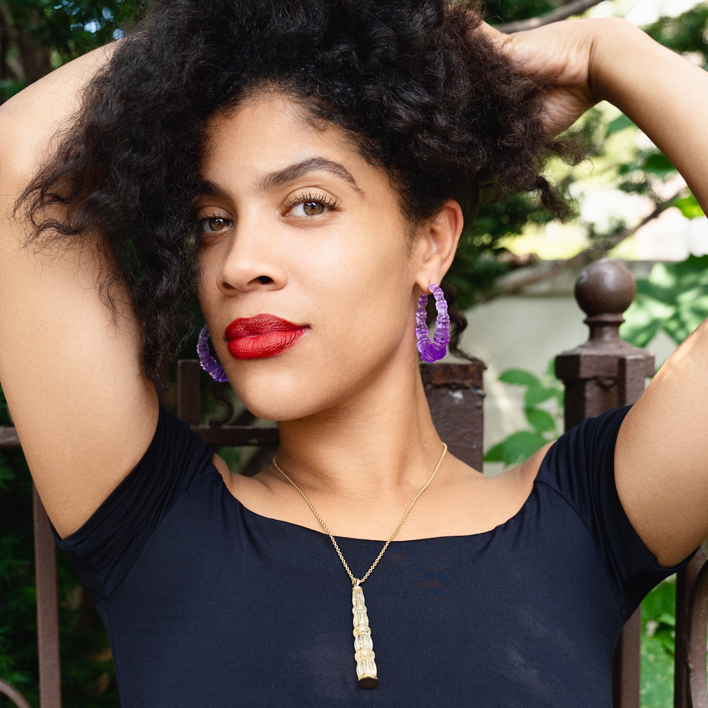 model wearing purple bamboo earrings and gold pendant necklace 