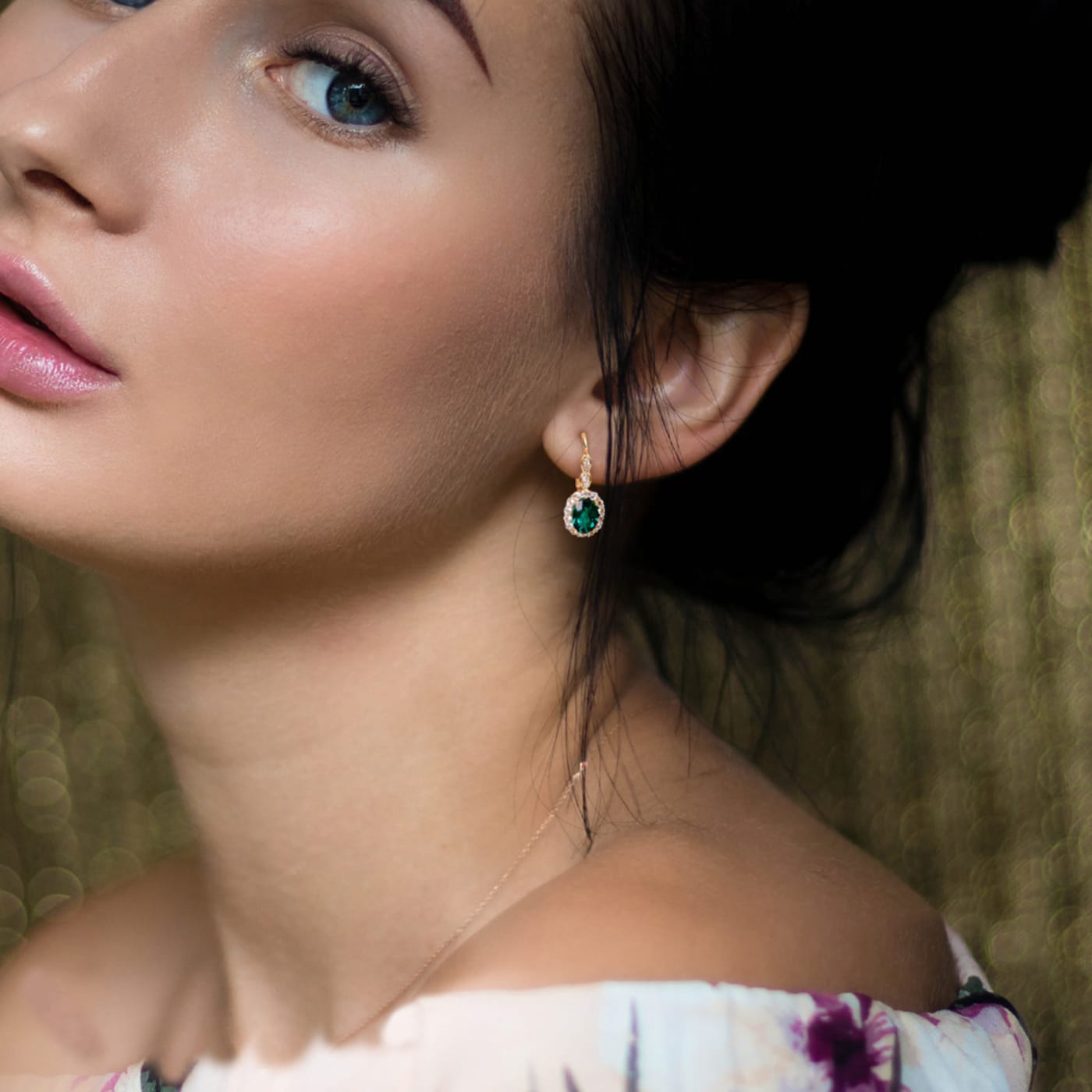 model wearing emerald and gold earrings 