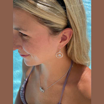 Sterling Silver Wave Dangle Earrings with Blue CZ Accents.