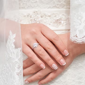 woman in white wearing engagement ring 