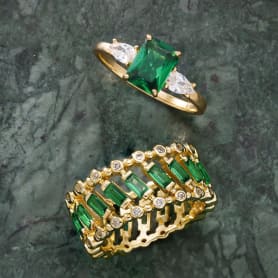 two green stone rings set in yellow gold