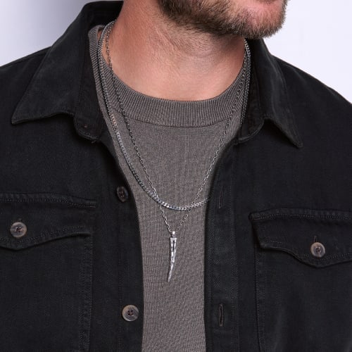 man wearing silver necklaces