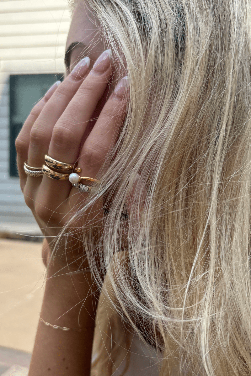 Woman's hand wearing both gold and silver rings