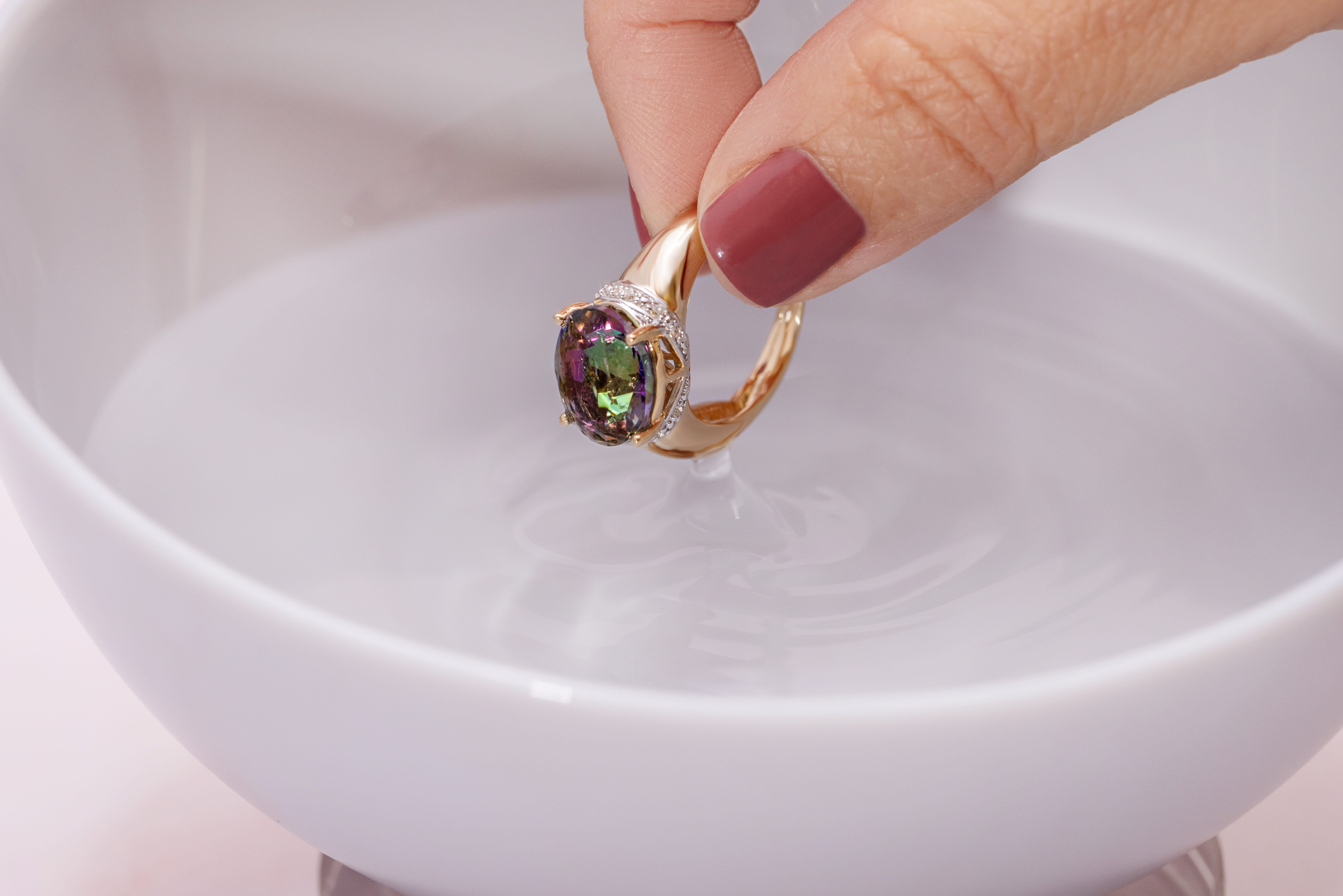 a multicolored gemstone ring is dipped in water