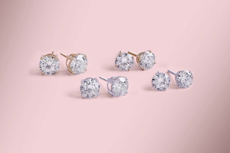 a group of gold and silver diamond stud earrings