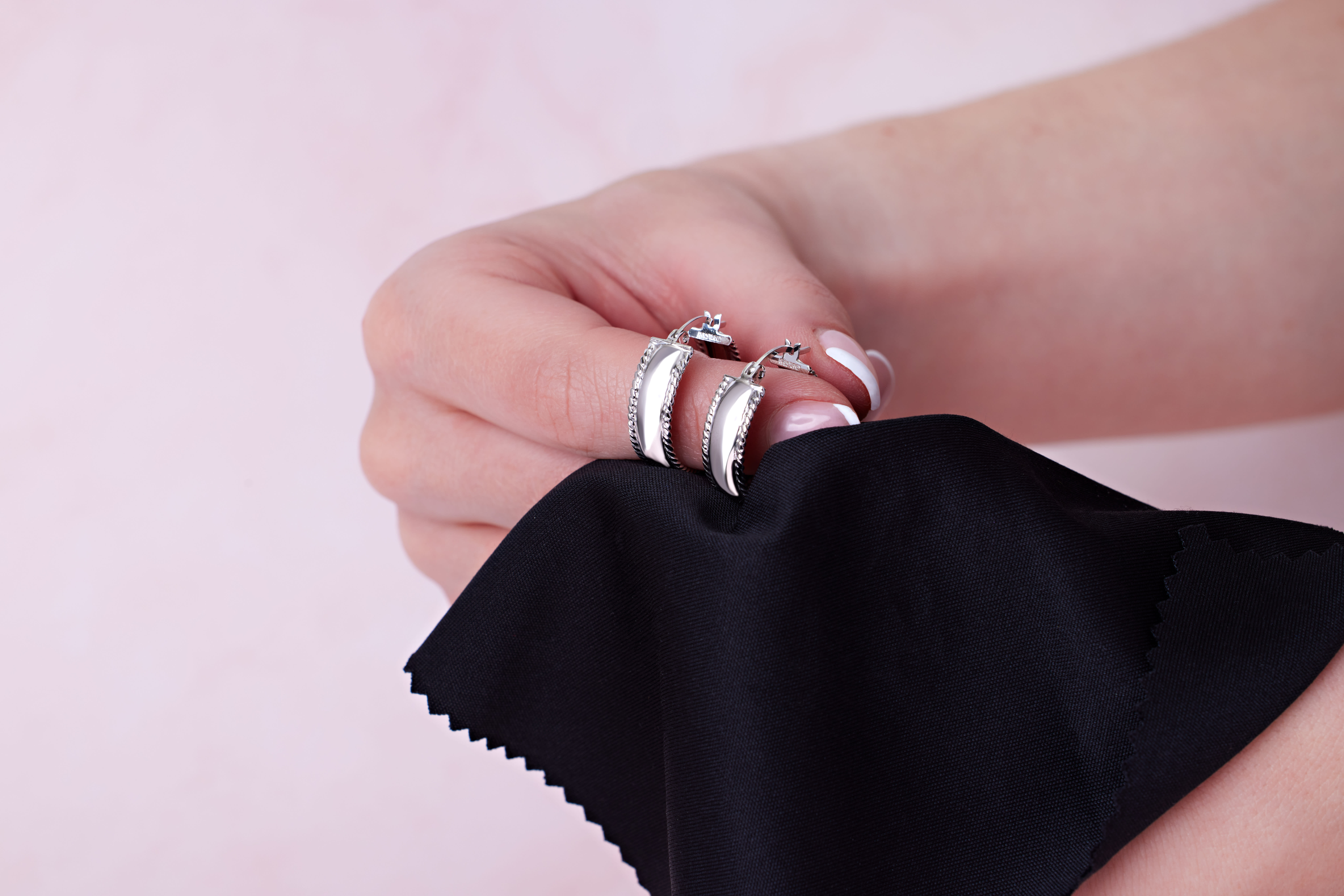 two sterling silver earrings are polished