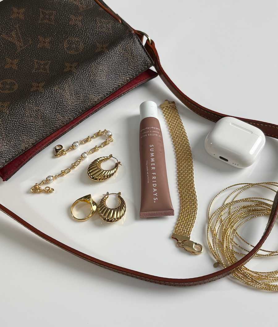 spilled purse featuring a bold hoop earring with a ring and bracelet stack to pair 