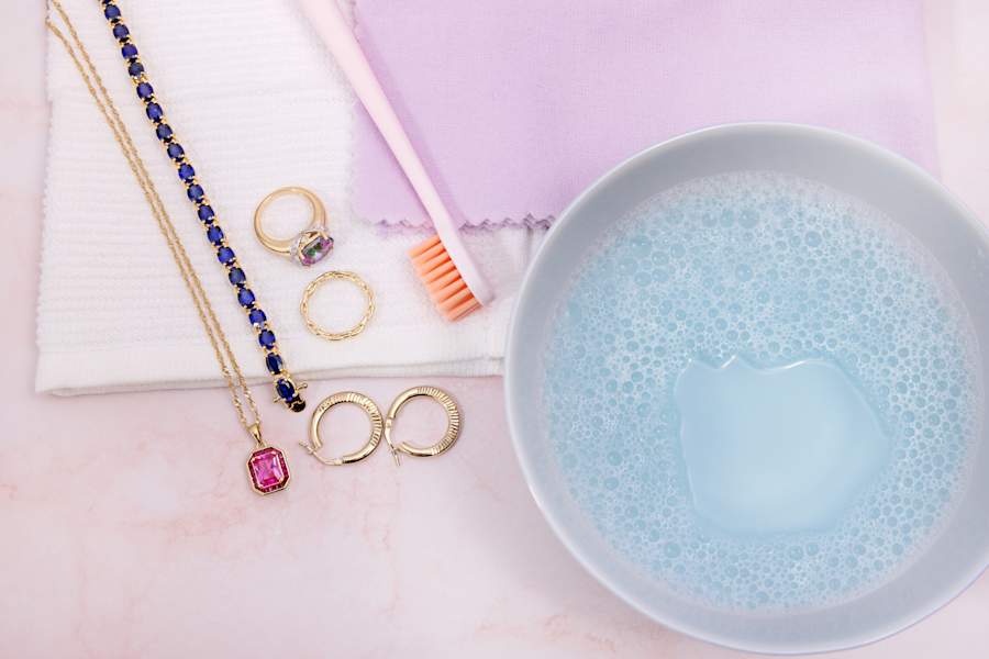 a collection of gold jewelry with cleaning supplies 