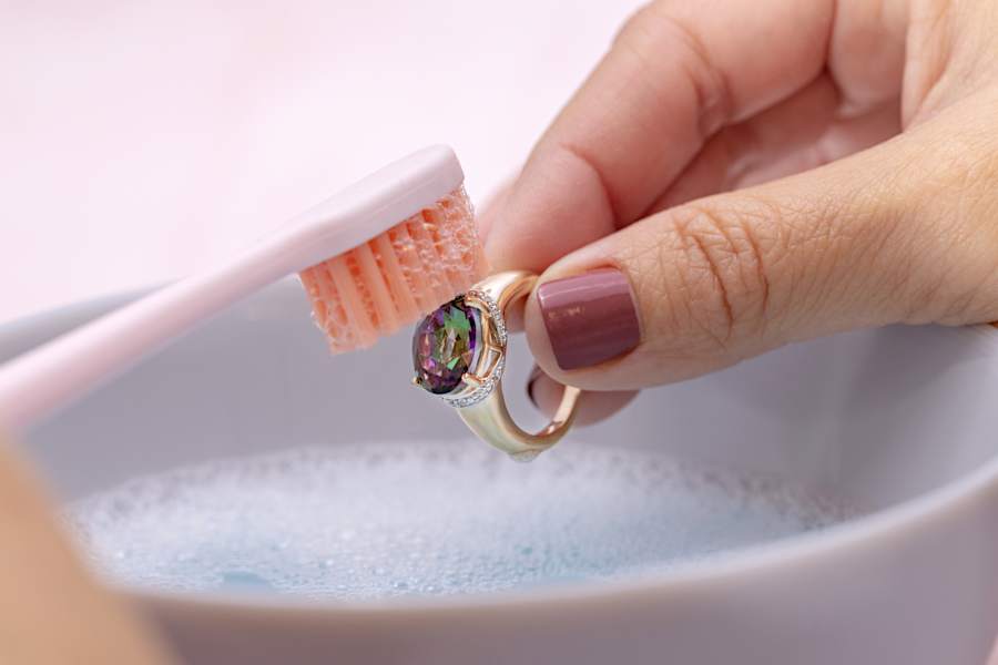 a multicolored gemstone ring being brushed gently 