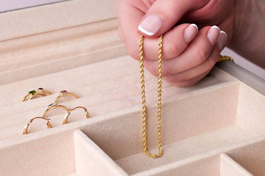 a gold chain necklace and a collection of gold rings 