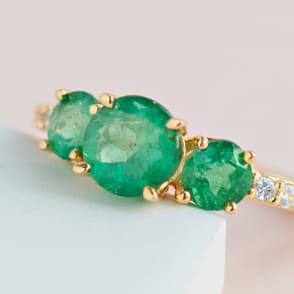 three stone emerald ring in gold