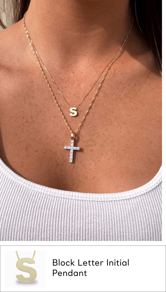 woman wearing all metal gold initial pendant