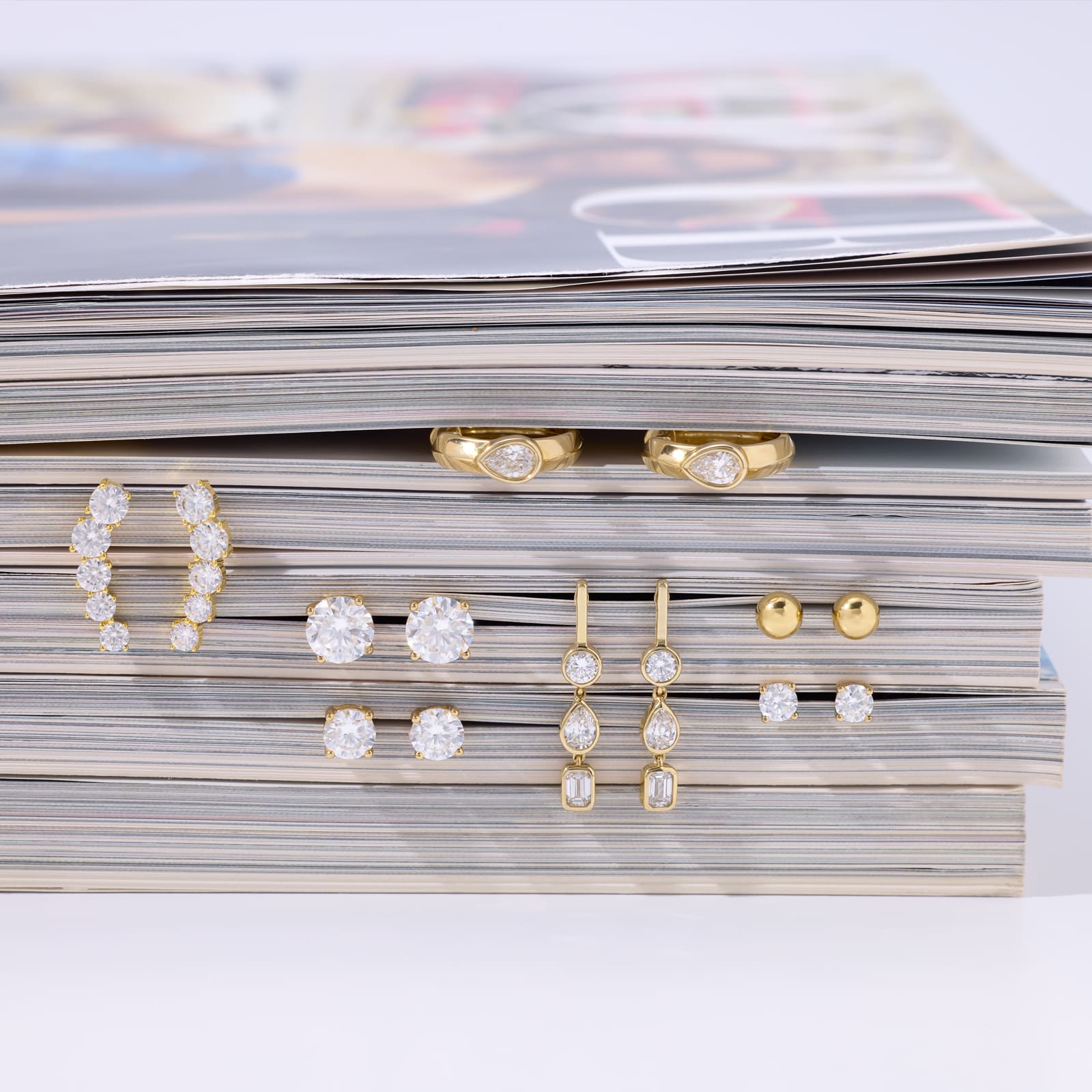 a mix of earrings and rings on a magazine 