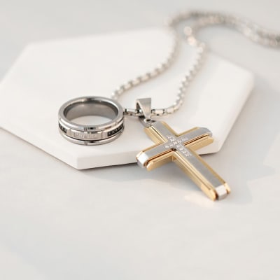 necklace with black and silver band ring and silver and gold cross pendant