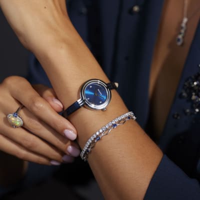 a silver and blue necklace and watch 