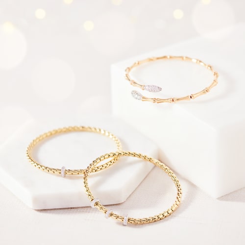 Three gold bracelets with diamond accents