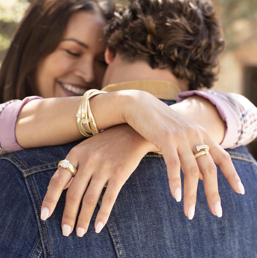 woman wearing bracelets and rings hugging man