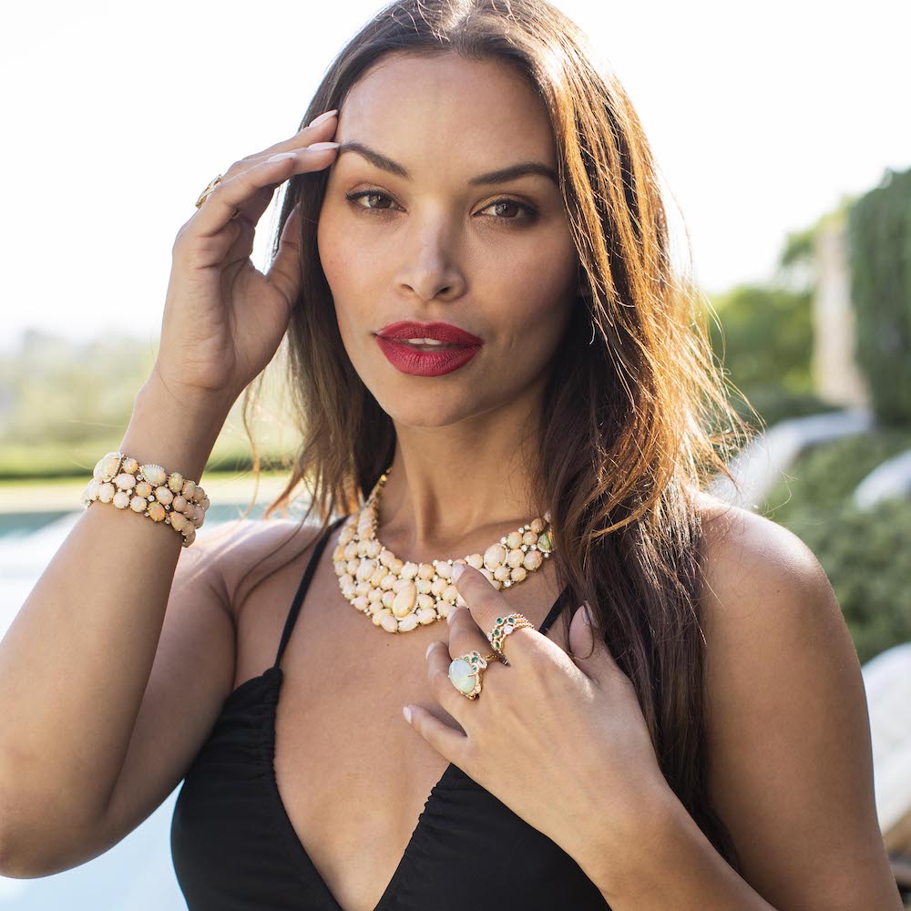 Model wearing bold opal collar necklace, matching bracelet and cocktail rings 