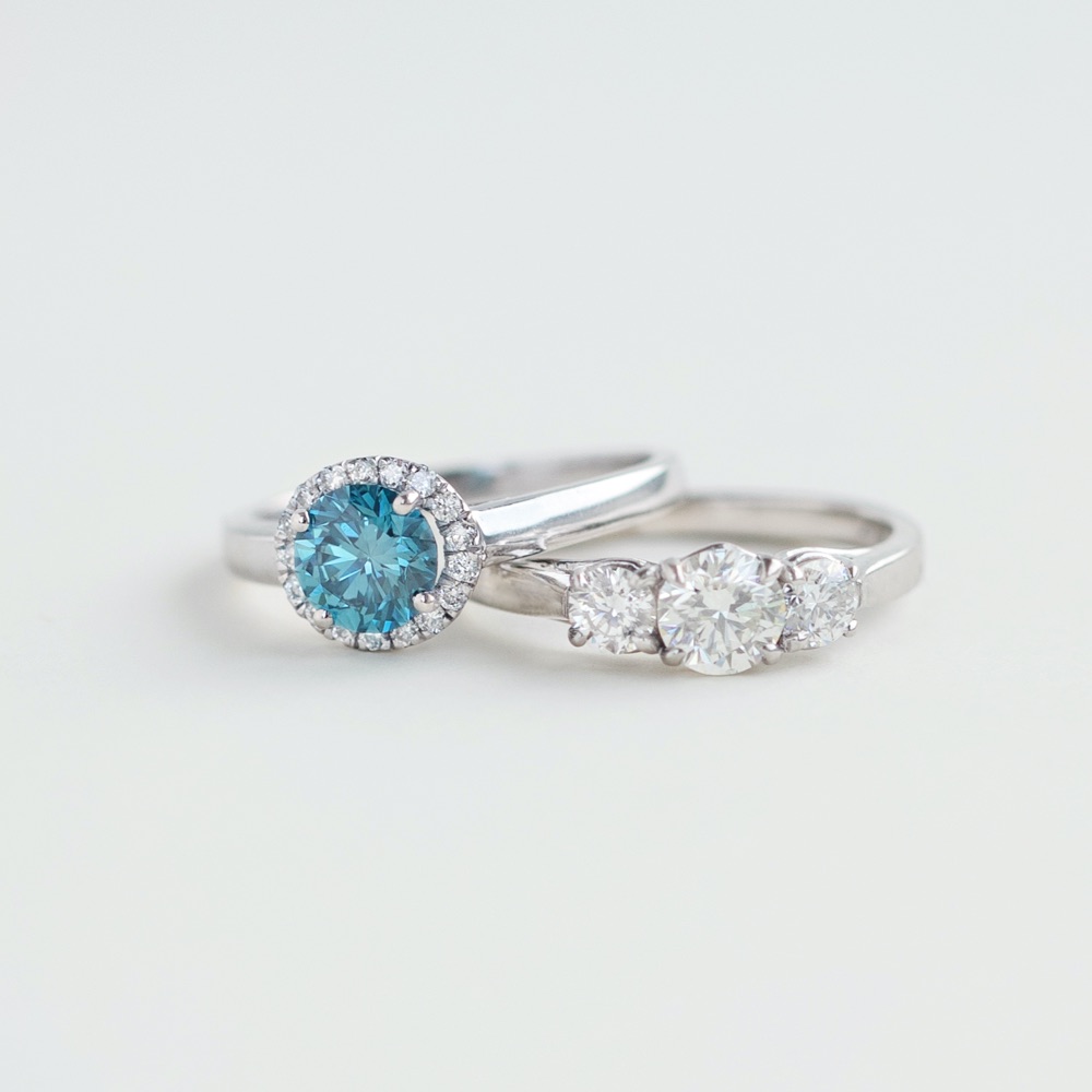 blue diamond ring and three stone white diamond ring 