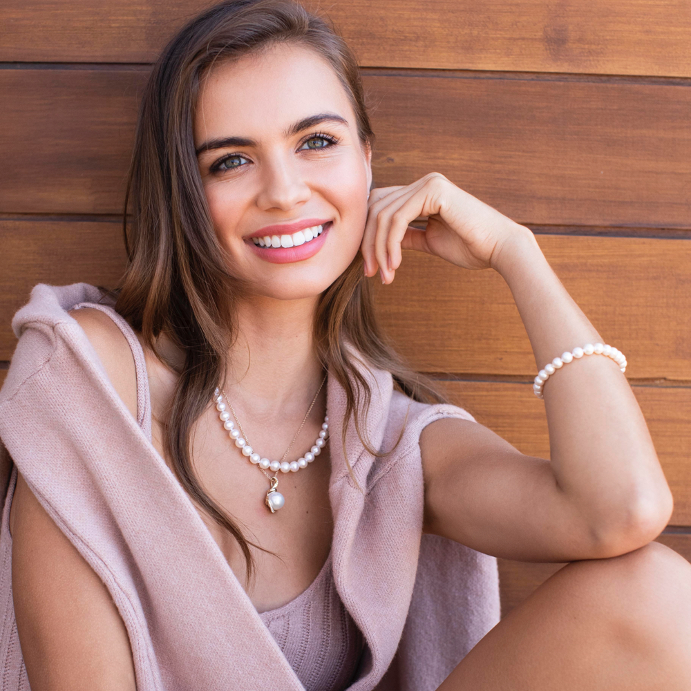 model wearing a casual pink outfit and lovely pearl jewelry pieces 