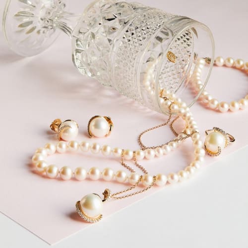 white pearl jewelry items in gold